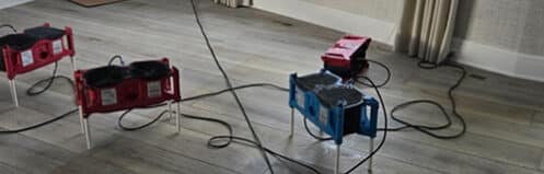 Professional drying mats and air movers on hardwood flooring - DriForce restoration equipment
